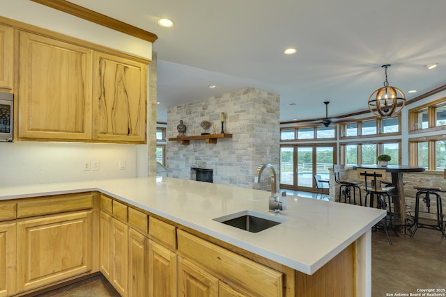 24005 Pedernales Canyon Trl, Spicewood, TX 78669 - kitchen with a sink, a stone fireplace, stainless steel microwave, recessed lighting, and a chandelier