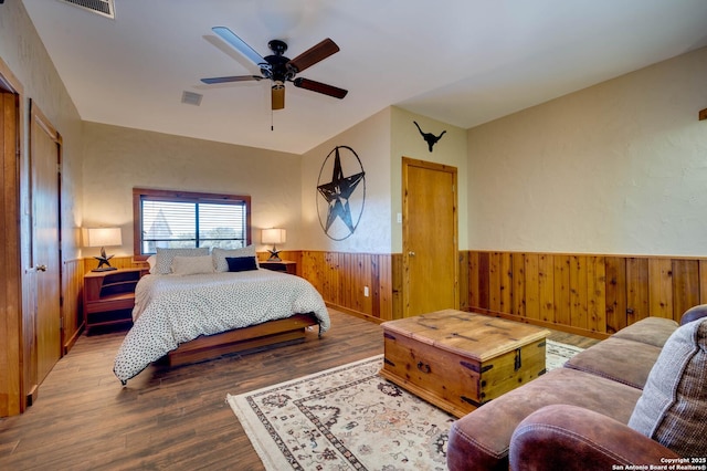24005 Pedernales Canyon Trl, Spicewood, TX 78669 - bedroom featuring wood finished floors, a wainscoted wall, wood walls, and ceiling fan