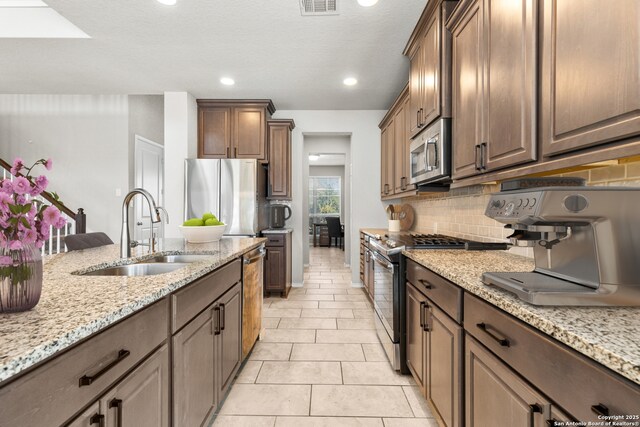 2126 Elysian, San Antonio, TX 78253 - kitchen with stainless steel appliances, a sink, decorative backsplash, light stone countertops, and recessed lighting