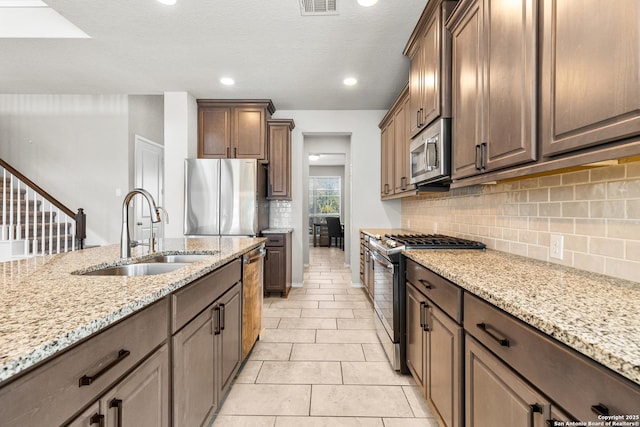 2126 Elysian, San Antonio, TX 78253 - kitchen with stainless steel appliances, a sink, light stone counters, backsplash, and light tile patterned floors