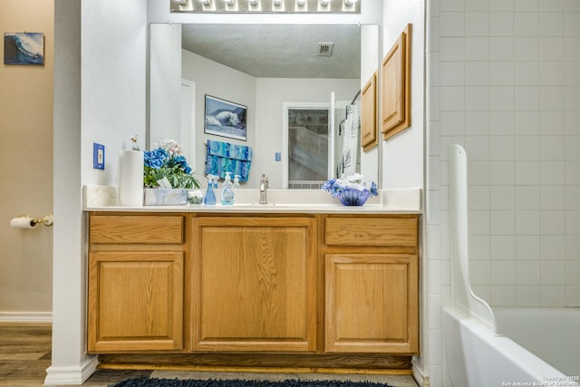 1027 Hedgestone, San Antonio, TX 78258 - full bath with vanity, wood finished floors, shower / tub combo with curtain, and a textured ceiling