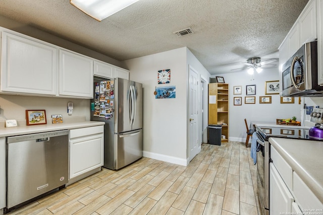 1027 Hedgestone, San Antonio, TX 78258 - kitchen featuring stainless steel appliances, baseboards, white cabinets, light countertops, and a textured ceiling