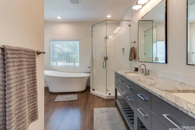 224 Frey, Boerne, TX 78006 - full bathroom with a shower stall, wood finished floors, double vanity, recessed lighting, and a freestanding bath