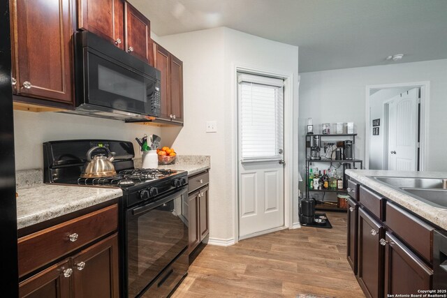 14718 Fronted Goose, San Antonio, TX 78253 - kitchen featuring black appliances, light wood-style flooring, light countertops, baseboards, and a sink