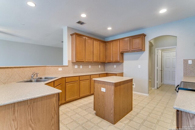 109 Sage Cyn, Boerne, TX 78006 - kitchen featuring a sink, arched walkways, light countertops, a center island, and light floors
