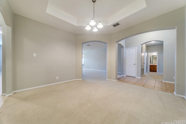 109 Sage Cyn, Boerne, TX 78006 - spare room with arched walkways, light colored carpet, a raised ceiling, ornamental molding, and a chandelier