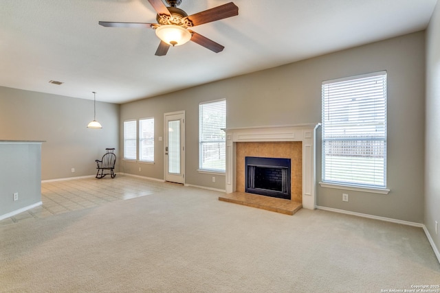 109 Sage Cyn, Boerne, TX 78006 - unfurnished living room featuring baseboards, a tiled fireplace, ceiling fan, and light colored carpet