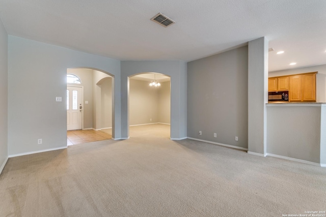 109 Sage Cyn, Boerne, TX 78006 - unfurnished living room with arched walkways, light carpet, recessed lighting, baseboards, and a chandelier