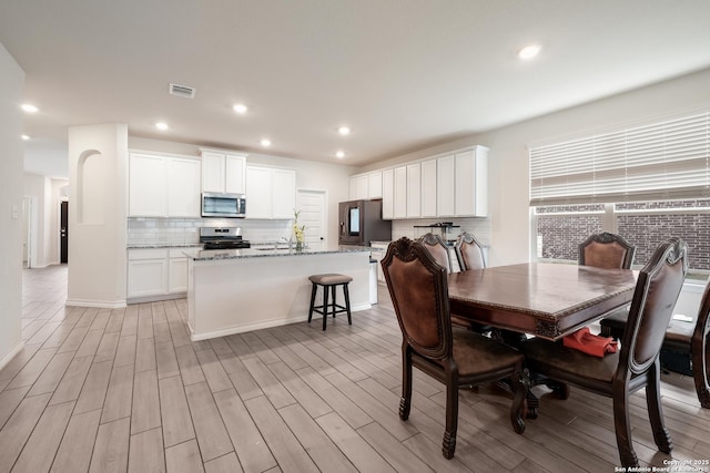 dining space with light wood-style flooring and recessed lighting