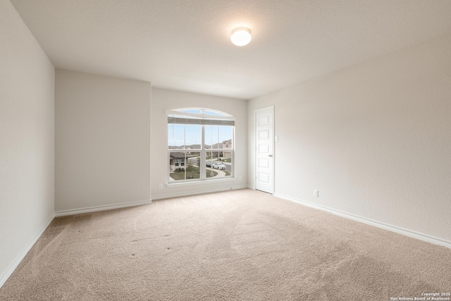 empty room with carpet and baseboards