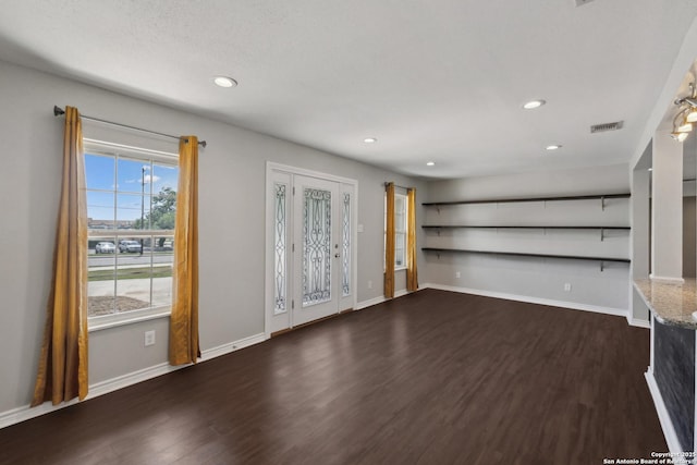 unfurnished living room with dark wood-type flooring, recessed lighting, and baseboards