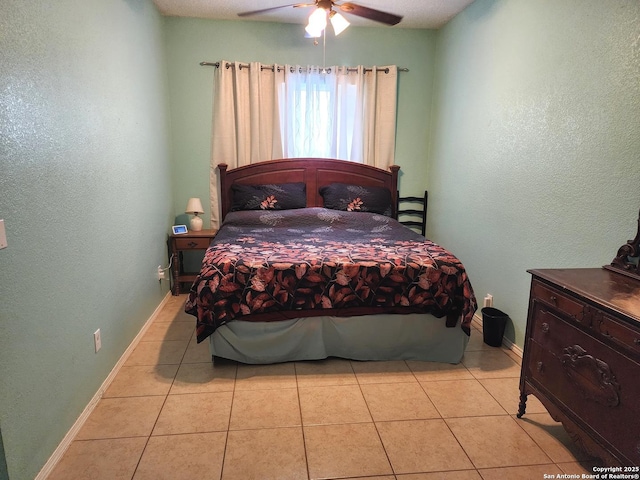 610 N 9th, Carrizo Springs, TX 78834 - tiled bedroom featuring baseboards, a ceiling fan, and a textured wall