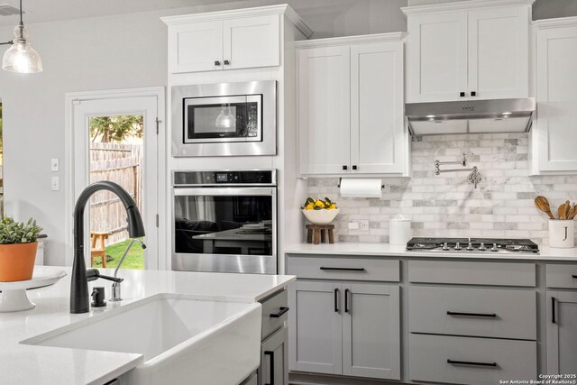 1527 Balcones Fault, New Braunfels, TX 78132 - kitchen with a sink, stainless steel appliances, gray cabinetry, and tasteful backsplash