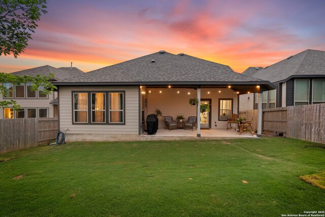 1527 Balcones Fault, New Braunfels, TX 78132 - back of house at dusk with a patio and a shingled roof