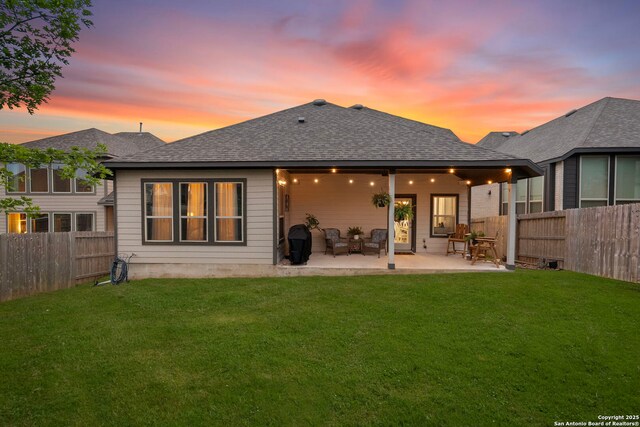 1527 Balcones Fault, New Braunfels, TX 78132 - back of property at dusk featuring a patio and roof with shingles