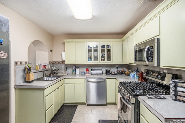 715 E Southcross, San Antonio, TX 78214 - kitchen featuring appliances with stainless steel finishes, a sink, light countertops, green cabinets, and a textured ceiling