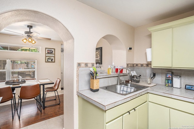 715 E Southcross, San Antonio, TX 78214 - kitchen featuring a sink, a ceiling fan, green cabinets, light countertops, and decorative backsplash