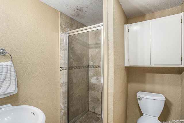 715 E Southcross, San Antonio, TX 78214 - bathroom with a stall shower, a textured wall, a textured ceiling, toilet, and a sink