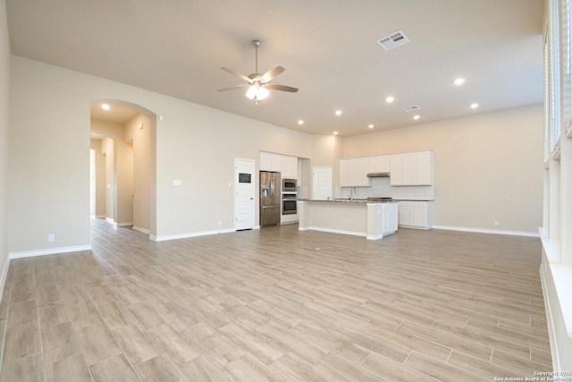 10809 Davis Farms, San Antonio, TX 78254 - unfurnished living room with ceiling fan, arched walkways, light wood-style floors, recessed lighting, and a sink
