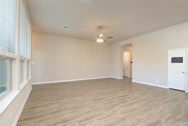 10809 Davis Farms, San Antonio, TX 78254 - spare room with a ceiling fan, arched walkways, light wood-type flooring, and baseboards