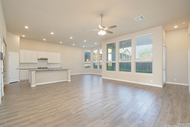 10809 Davis Farms, San Antonio, TX 78254 - unfurnished living room featuring ceiling fan, plenty of natural light, light wood finished floors, recessed lighting, and baseboards