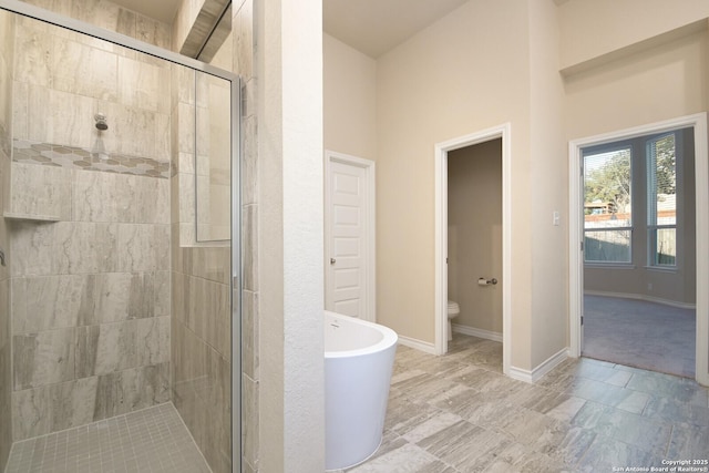 10809 Davis Farms, San Antonio, TX 78254 - bathroom featuring a shower stall, toilet, a freestanding tub, and baseboards