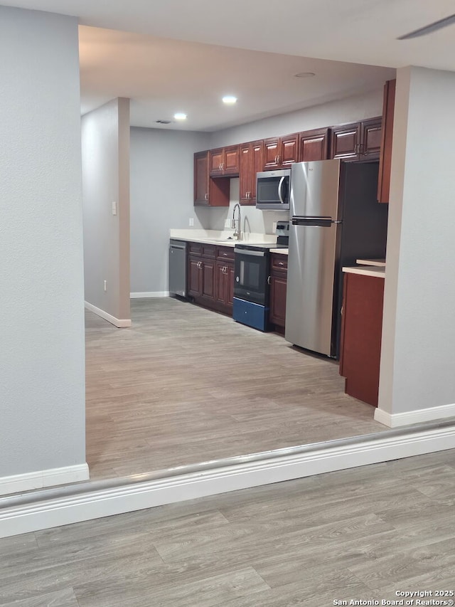 110 Heather Ave, San Antonio, TX 78223 - kitchen featuring stainless steel appliances, baseboards, light countertops, light wood-type flooring, and recessed lighting