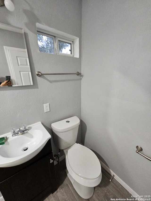 110 Heather Ave, San Antonio, TX 78223 - half bathroom with toilet, vanity, wood finished floors, and baseboards