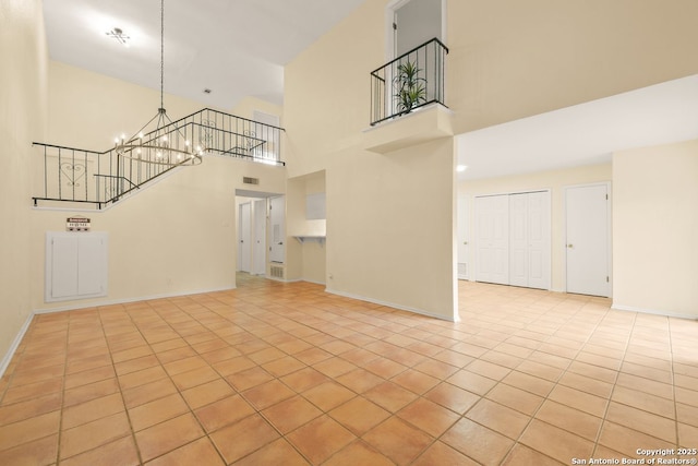6123 Farragut, San Antonio, TX 78238 - unfurnished living room with light tile patterned floors, a towering ceiling, a chandelier, and baseboards