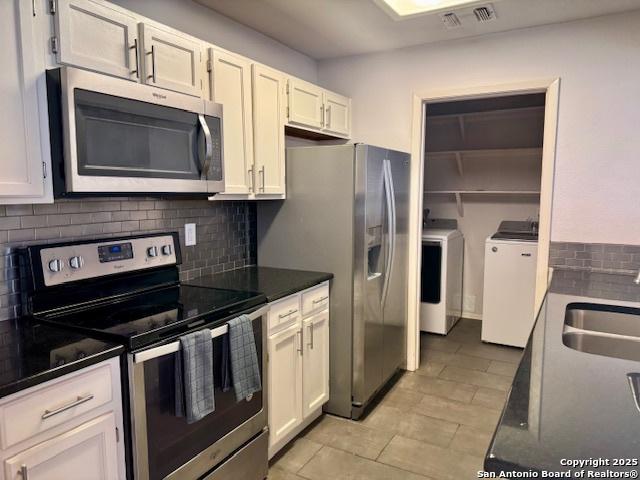 5739 Spring Moon, San Antonio, TX 78247 - kitchen with appliances with stainless steel finishes, washing machine and clothes dryer, tasteful backsplash, white cabinets, and a sink