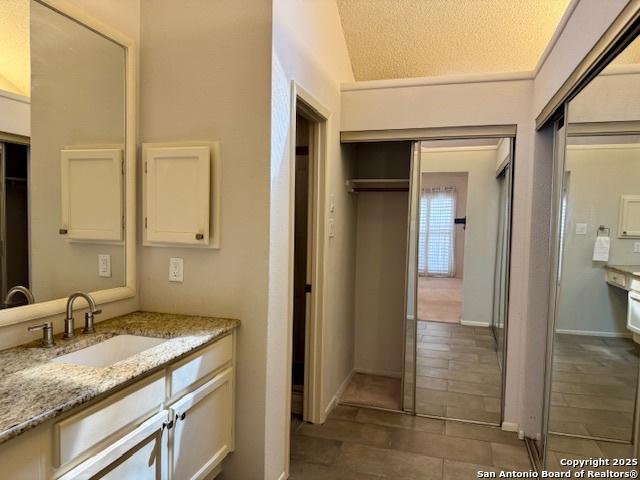 5739 Spring Moon, San Antonio, TX 78247 - bathroom featuring vanity, tile patterned flooring, and a textured ceiling