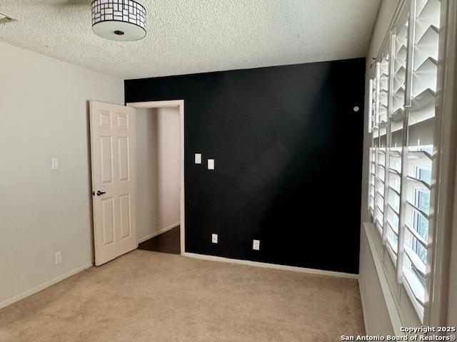 5739 Spring Moon, San Antonio, TX 78247 - empty room featuring carpet, a textured ceiling, and baseboards