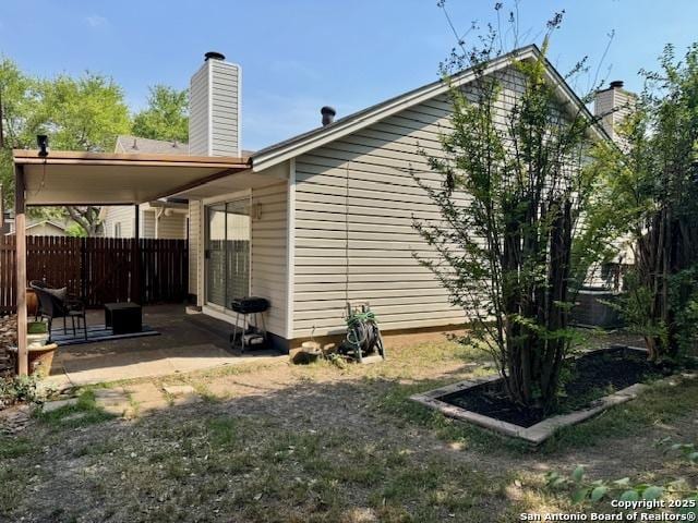 5739 Spring Moon, San Antonio, TX 78247 - view of side of property featuring a patio area, fence, and a chimney