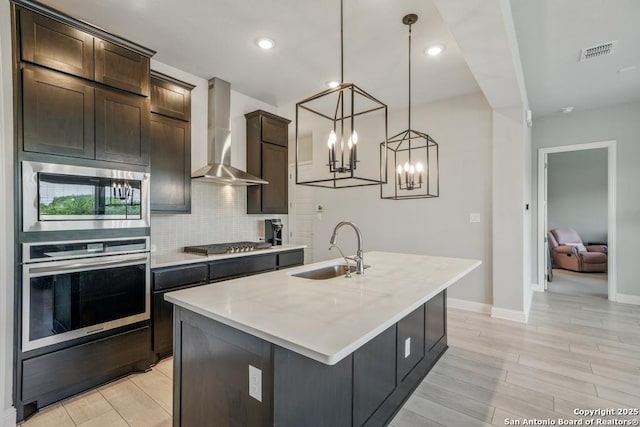 355 Jereth, Castroville, TX 78009 - kitchen with appliances with stainless steel finishes, wall chimney exhaust hood, a sink, light countertops, and tasteful backsplash