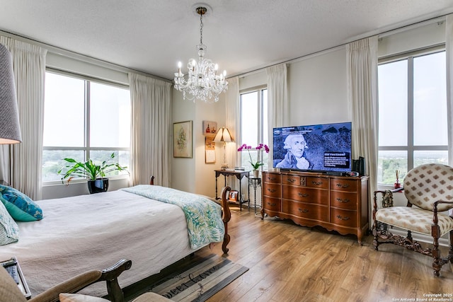 1 Towers Park Ln Unit 907, San Antonio, TX 78209 - bedroom featuring a chandelier, wood finished floors, and a textured ceiling
