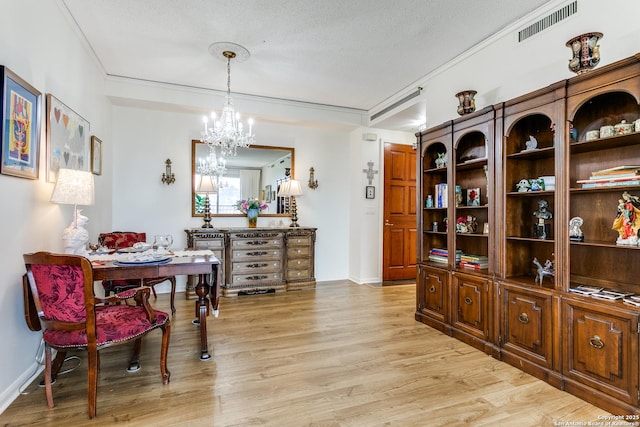 1 Towers Park Ln Unit 907, San Antonio, TX 78209 - dining space featuring light wood-type flooring, a chandelier, a textured ceiling, and baseboards