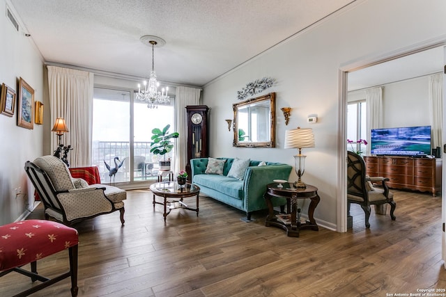 1 Towers Park Ln Unit 907, San Antonio, TX 78209 - living room with healthy amount of natural light, a chandelier, wood finished floors, baseboards, and a textured ceiling