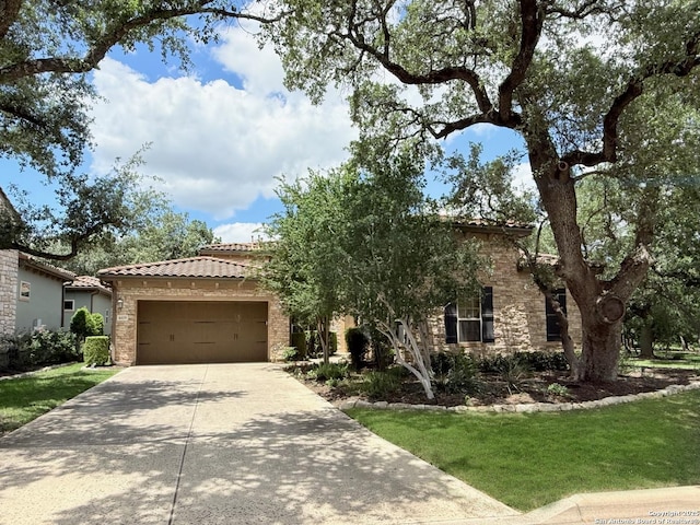 4419 Tapia, San Antonio, TX 78261 - view of front of home featuring a garage, concrete driveway, a tiled roof, stone siding, and a front yard