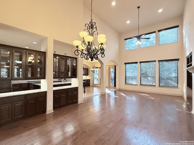 4419 Tapia, San Antonio, TX 78261 - unfurnished dining area featuring arched walkways, high vaulted ceiling, a ceiling fan, dark wood-type flooring, and a chandelier