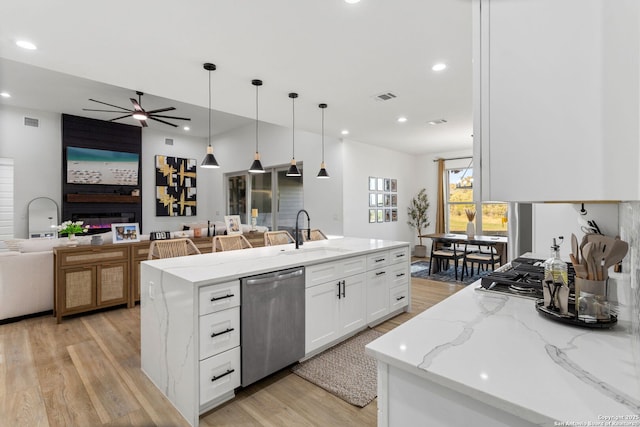 187 Stone Loop, Castroville, TX 78009 - kitchen with stainless steel dishwasher, a sink, open floor plan, a ceiling fan, and light wood-style floors
