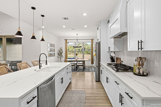 187 Stone Loop, Castroville, TX 78009 - kitchen with a sink, stainless steel appliances, decorative backsplash, recessed lighting, and light wood-style flooring