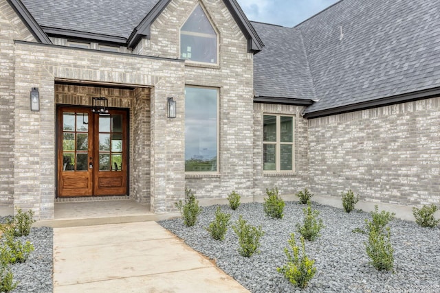 187 Stone Loop, Castroville, TX 78009 - property entrance featuring french doors, brick siding, and a shingled roof