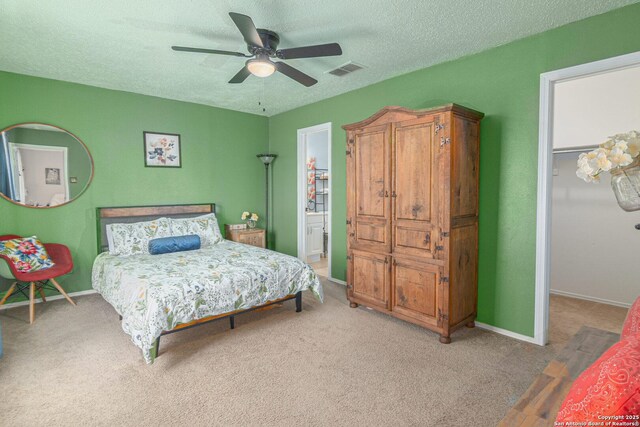 926 Zwicke, Seguin, TX 78155 - carpeted bedroom featuring a textured ceiling, a walk in closet, a ceiling fan, baseboards, and a closet