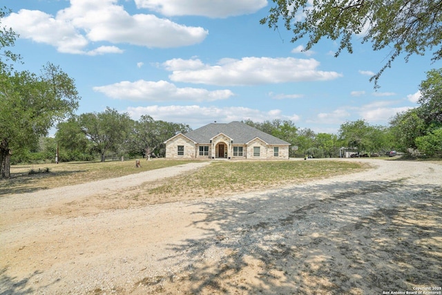 346 Broken Arrow, Floresville, TX 78114 - view of front of property featuring driveway, stone siding, and a front lawn