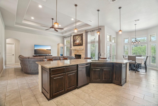 346 Broken Arrow, Floresville, TX 78114 - kitchen featuring dishwasher, a sink, a stone fireplace, ceiling fan, and dark brown cabinetry