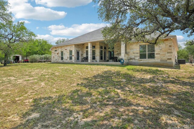 346 Broken Arrow, Floresville, TX 78114 - back of property featuring stone siding, a yard, and cooling unit