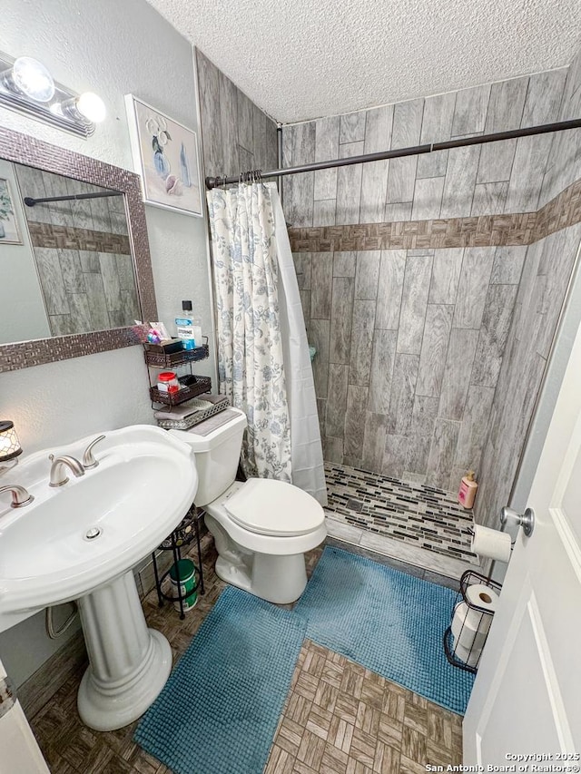 602 Hortencia Ave, San Antonio, TX 78237 - full bathroom featuring a shower stall, a textured ceiling, toilet, and a textured wall