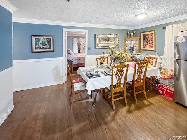 602 Hortencia Ave, San Antonio, TX 78237 - dining area with a textured ceiling, wood finished floors, a wainscoted wall, and ornamental molding