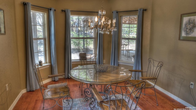 211 Roy Chisum Rd, Leakey, TX 78873 - dining space featuring wood finished floors, baseboards, a chandelier, and healthy amount of natural light