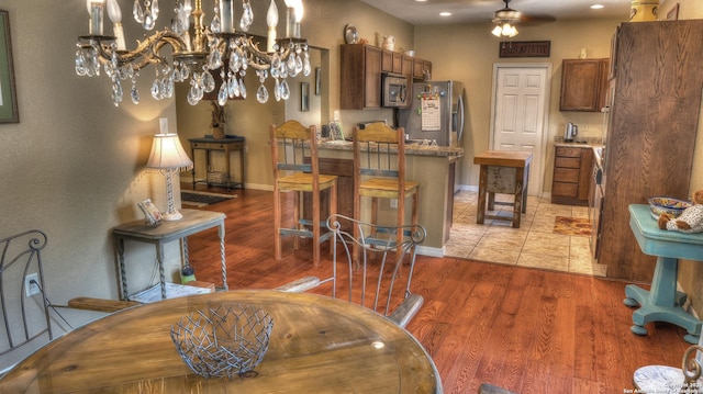 211 Roy Chisum Rd, Leakey, TX 78873 - dining area with ceiling fan, wood finished floors, baseboards, and a chandelier